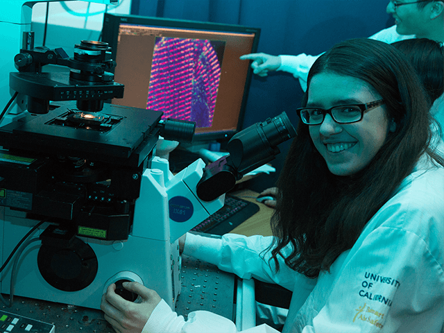 An BPH graduate student works at a microscope